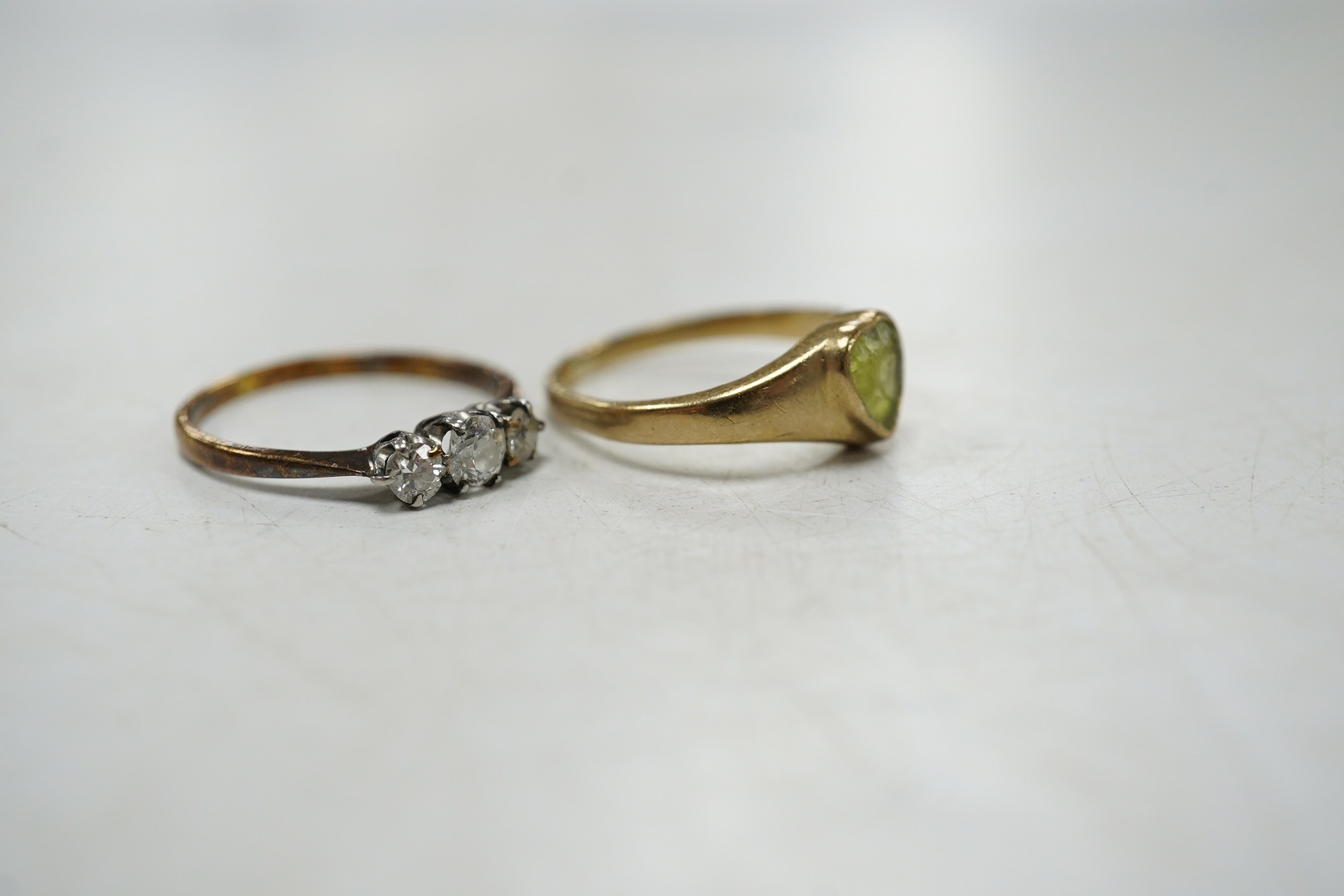 An 18ct and three stone diamond set ring, size G and one other 9ct gold and heart shaped green stone set ring. Condition - poor to fair